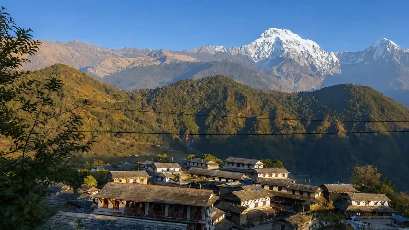 Ghandruk village landscape featuring traditional stone architecture and the Annapurna mountain range during autumn.