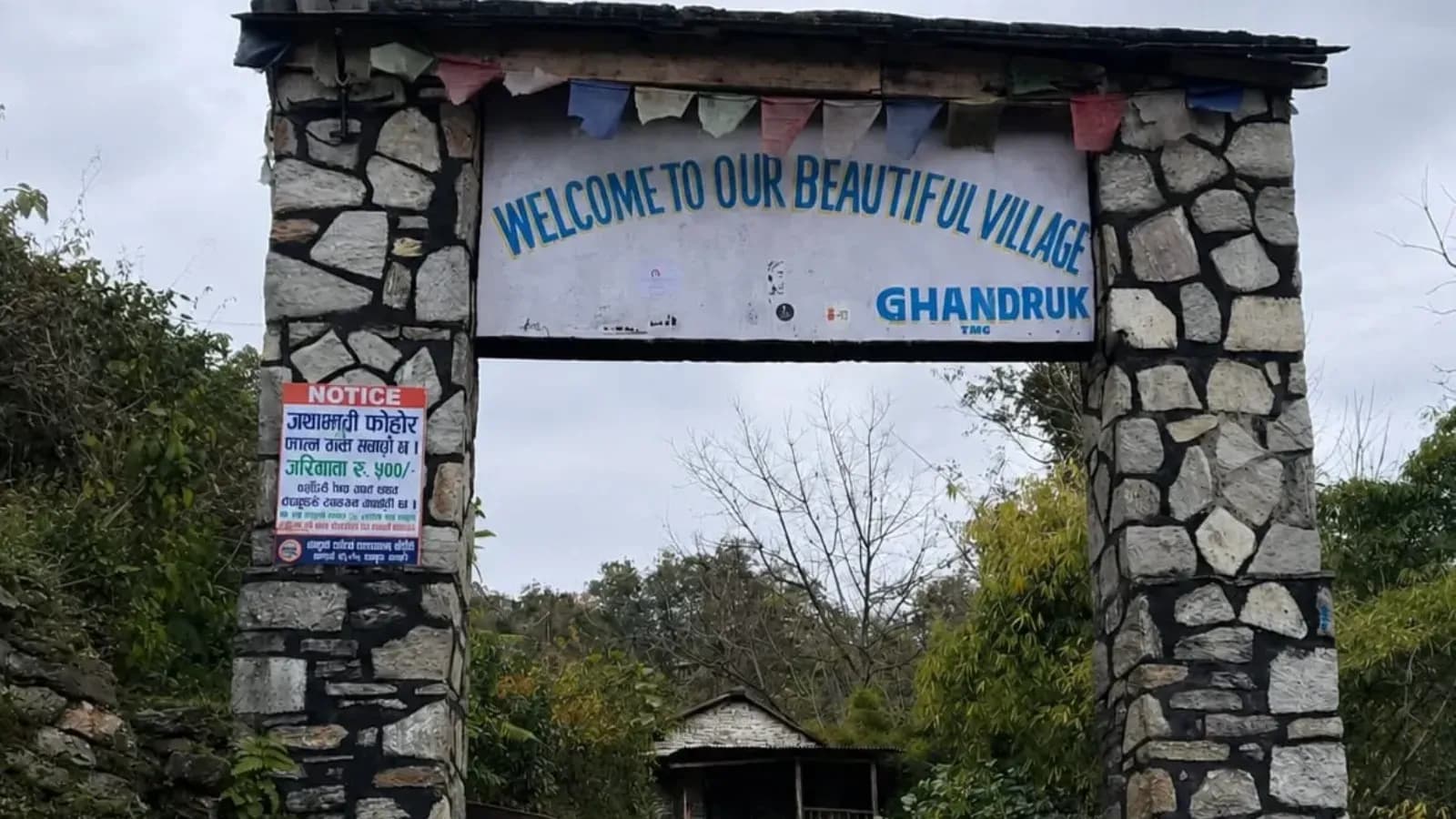 Stone entrance gate welcoming trekkers to Ghandruk village in the Annapurna region.